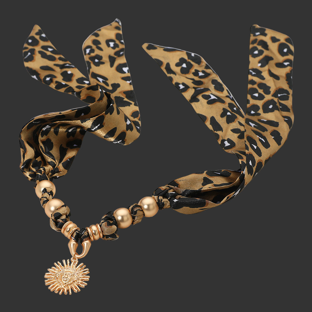 Leopard print necklace with gold beads and a sunflower charm on a beige background